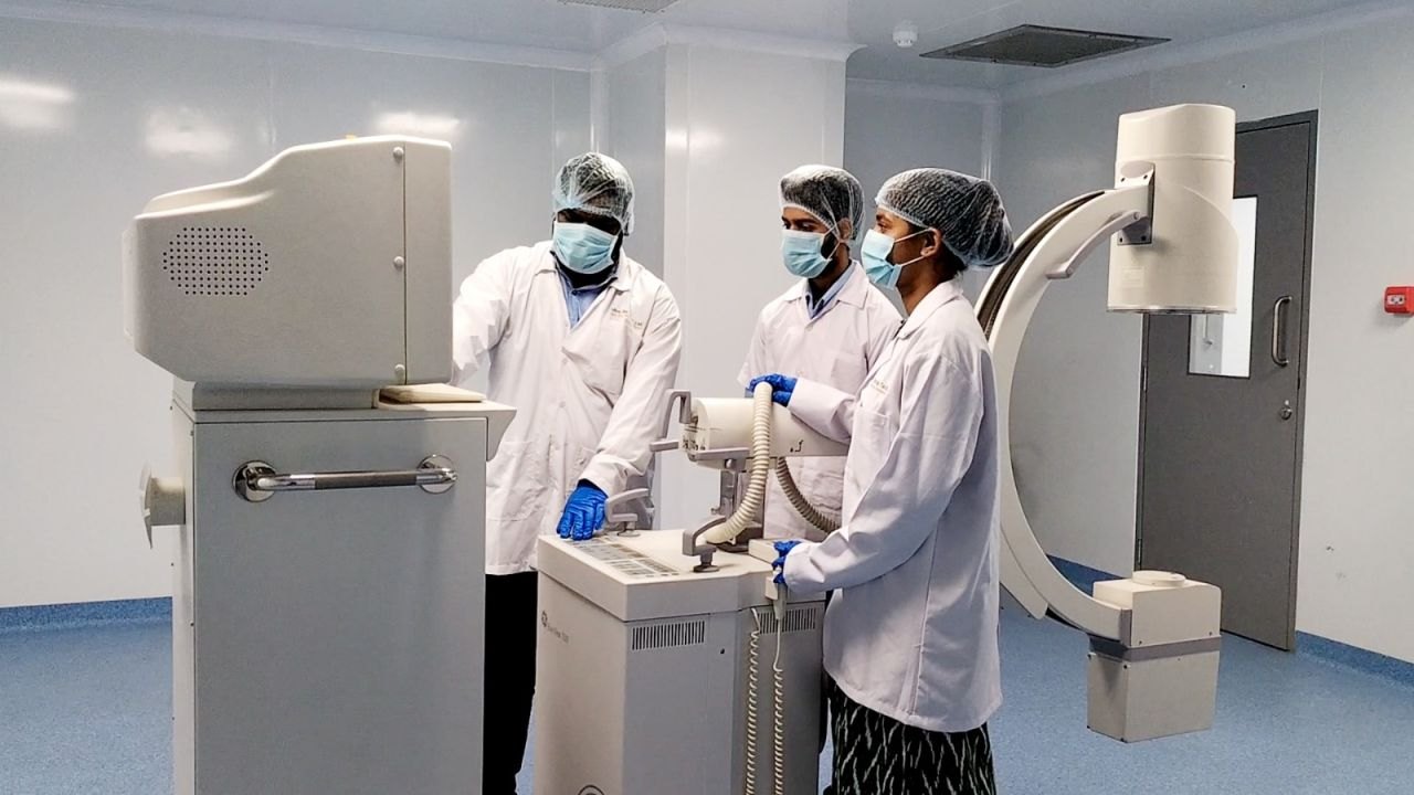 Researchers operating a C-arm imaging system in the modular operation theatre